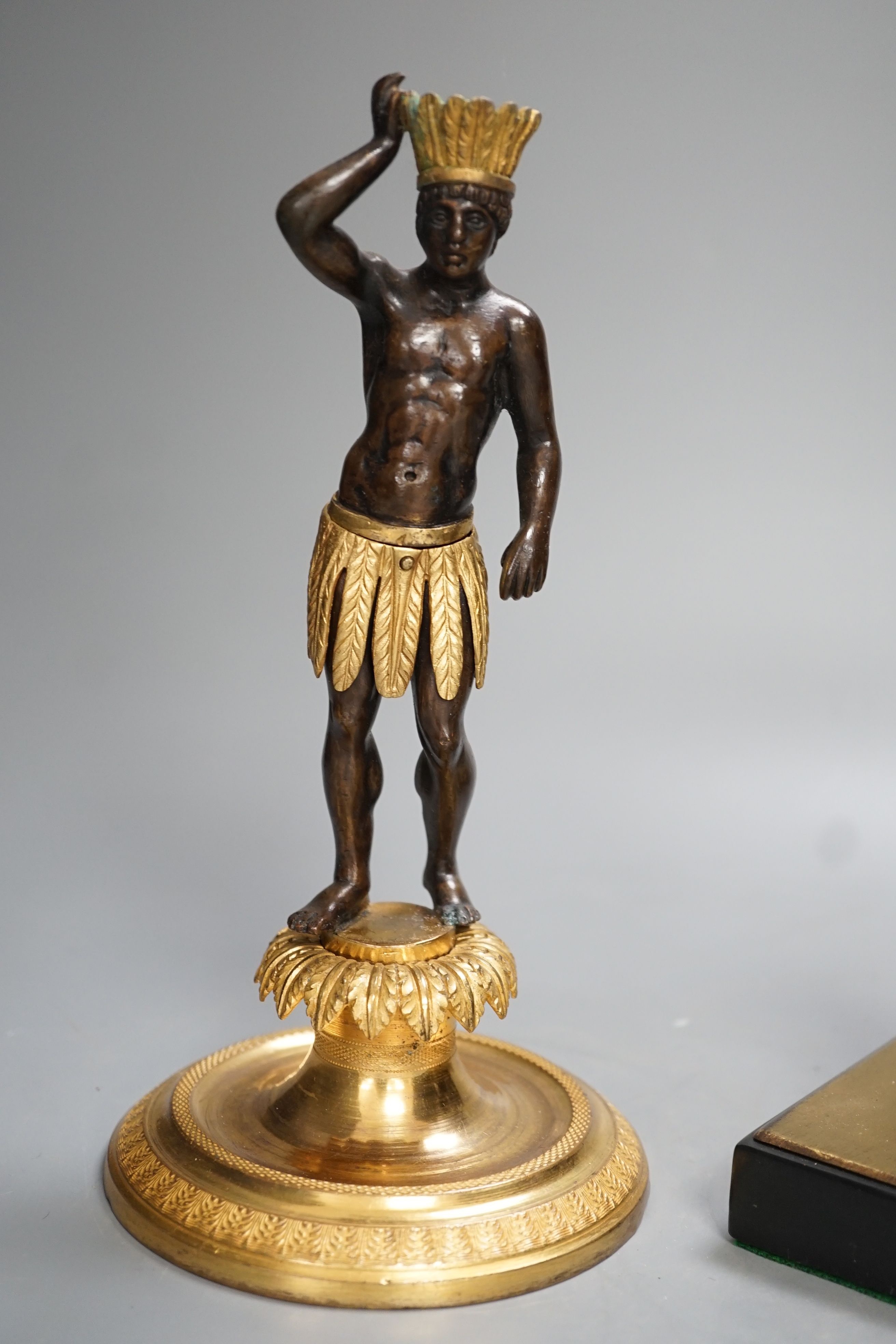 A patinated metal model of a sphinx and a bronze and gilt figure of a Nubian man. 22cm